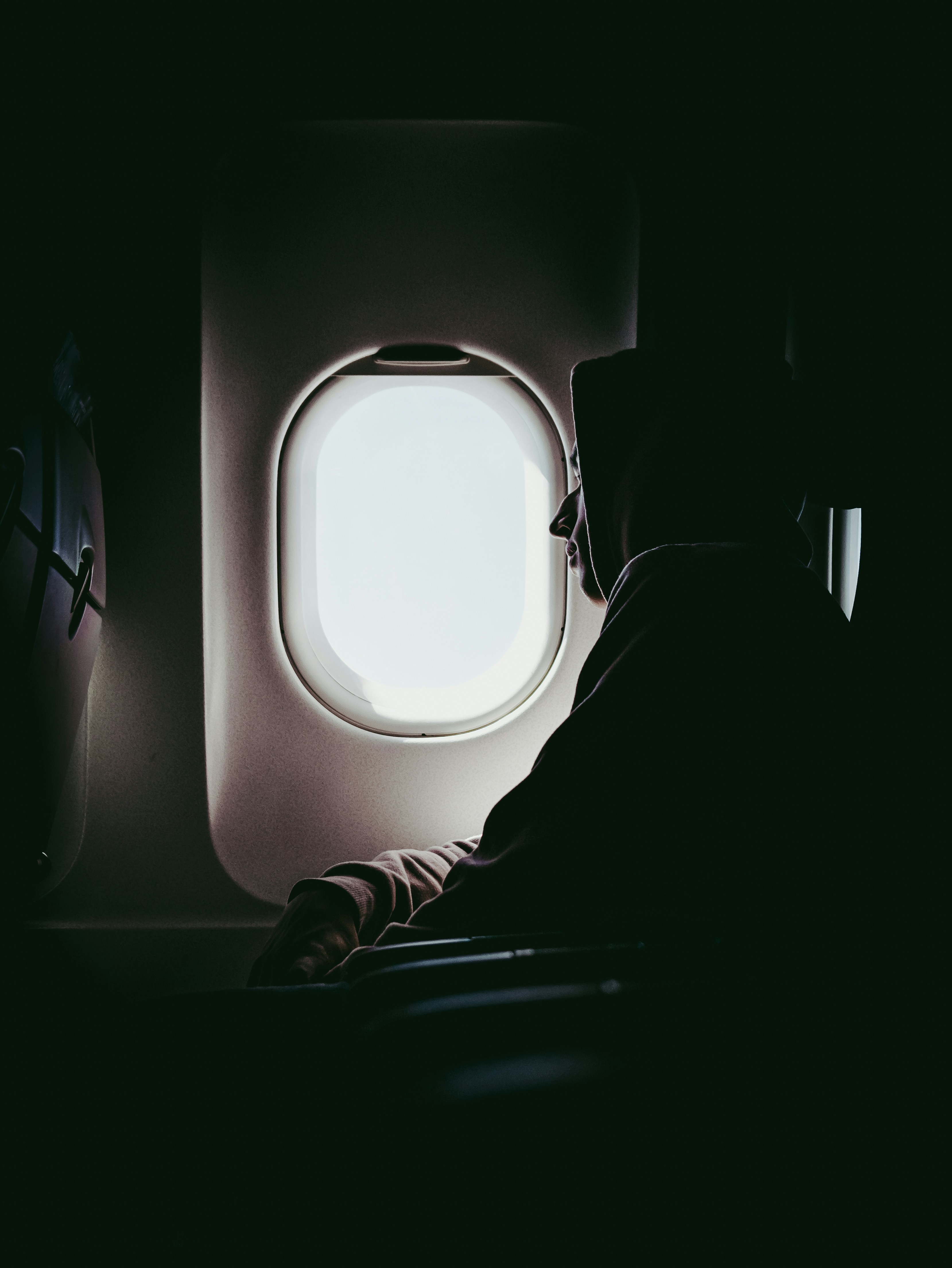 Guy looking out window on plane.